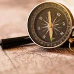A stylized illustration of a compass sitting on top of a technical blueprint, representing professional intuition